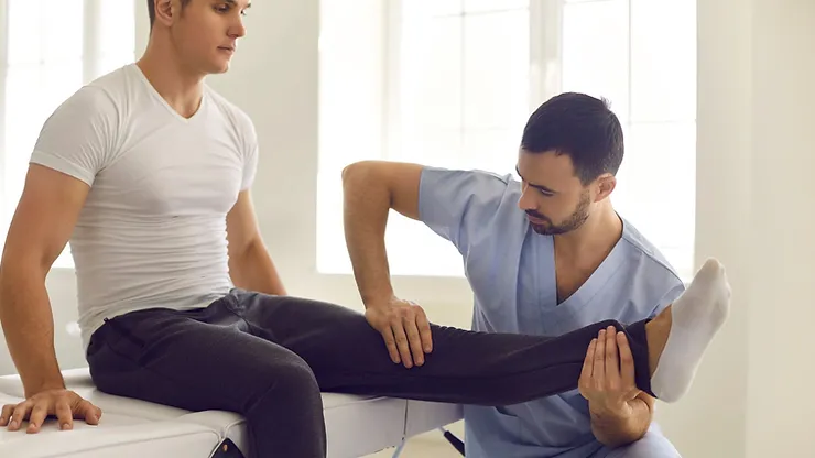 patient receiving therapy on his knee from a physical therapist 